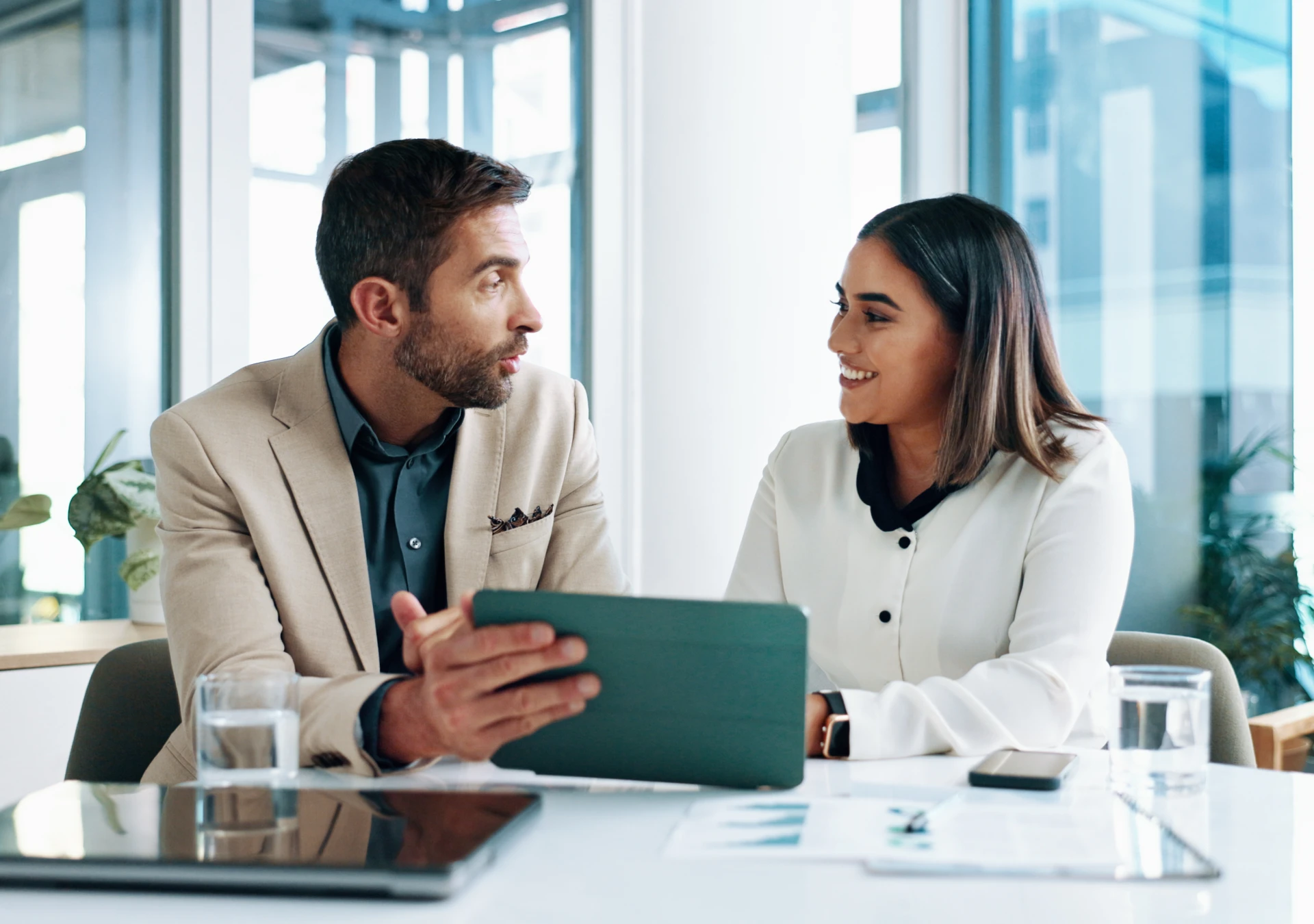 Two colleagues discussing work at a table.